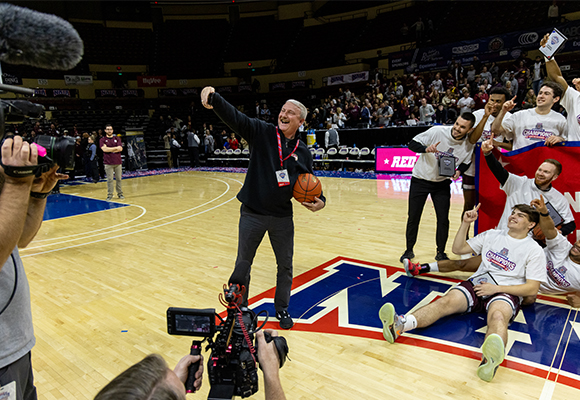President Shannon takes a selfie in front of Lions basketball team.