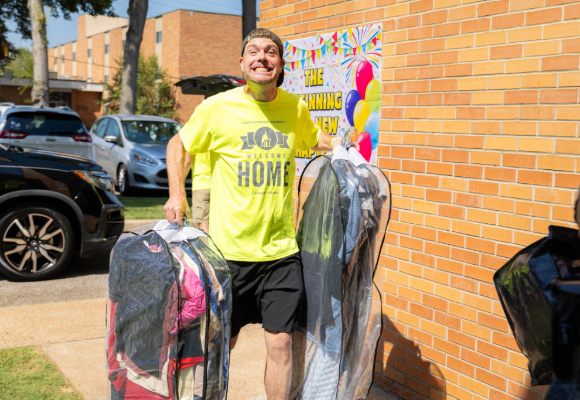 Welcome Home FHU Staff helping carry a new students items to their room