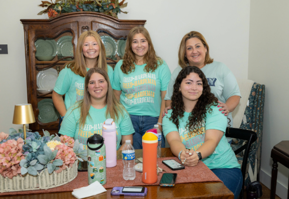 Hall Rolands Dorm staff sitting in the dorm lobby ready to "Welcome Home" new students