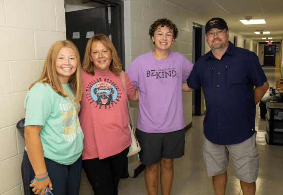 Welcome Home new student family standing in the dorm hallway