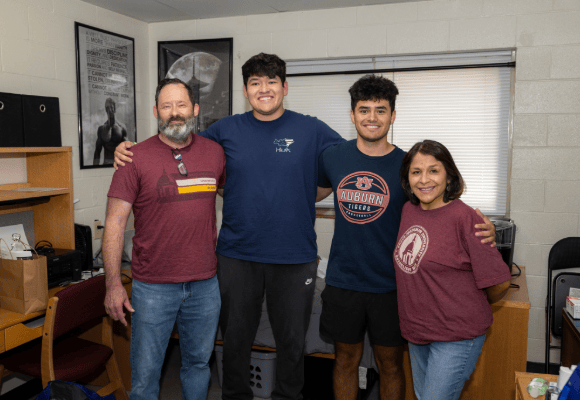 Welcome Home new male student family standing with him in his dorm room