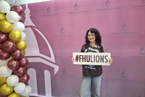 A student poses for her first picture on campus move in day.