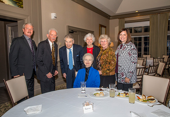 David and Tracie Shannon stand with guests behind a dinner table.