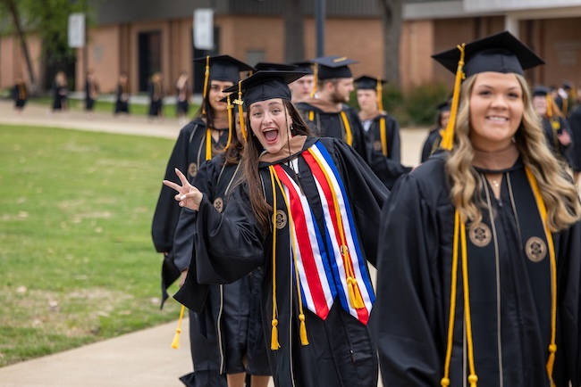 FHU graduates walk through the commons on their way to Dryden Auditorium.
