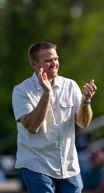 Keith Harris clapping as he watches a game