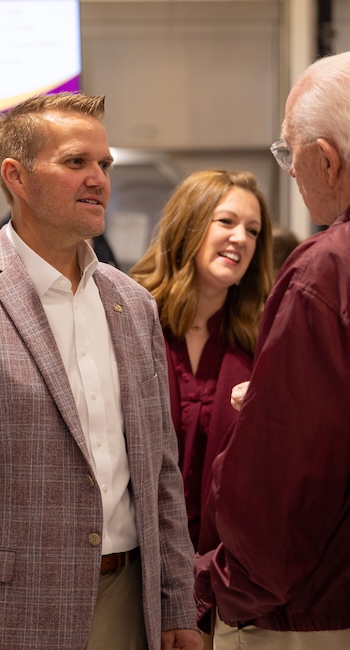 Keith and Lyndsey Harris talking to an older alumn