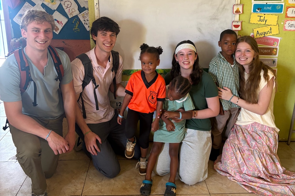 Omega Chi students pose with a child during their campaign in Santa Cruz, Jamaica.