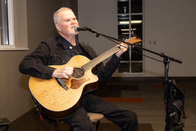 Man plays guitar for guests during the FHU Benefit Dinner meal
