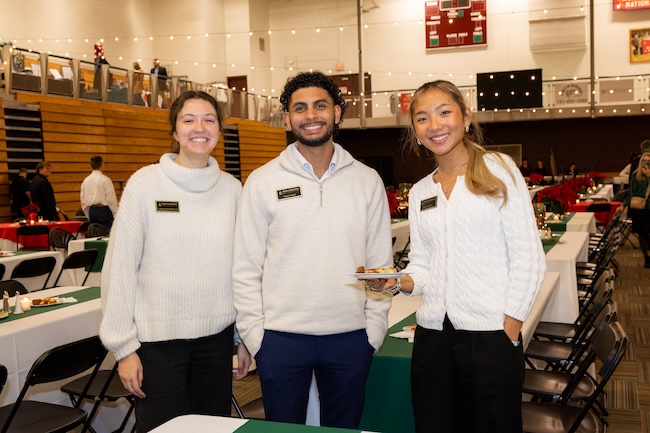 Three staff members serve food in Brewer Sports Center
