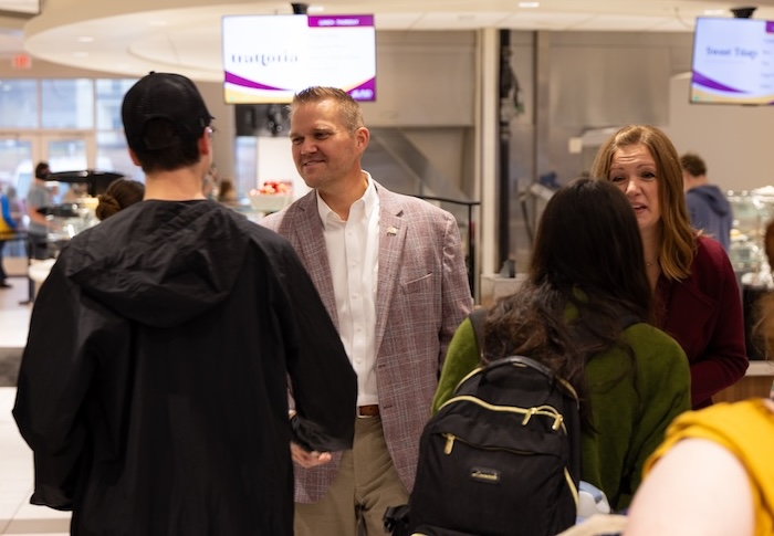 Dr. Keith Harris and his wife, Lindsey, visit with students in Jones Dining Hall