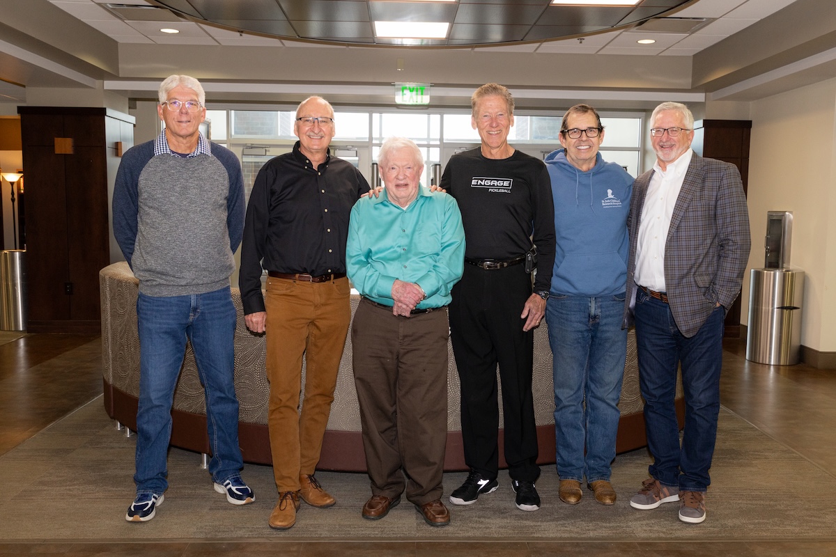Doc Woods poses with alumni who played tennis for him as young men.