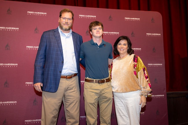 FHU parents stand with their son following the Legacy Pinning Ceremony