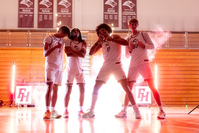 Four members of the FHU Men's Basketball team pose in gym