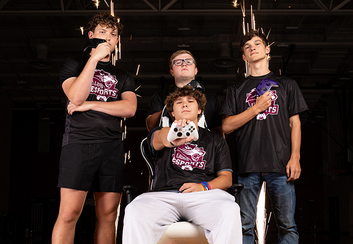 FHU esports players holding game controllers