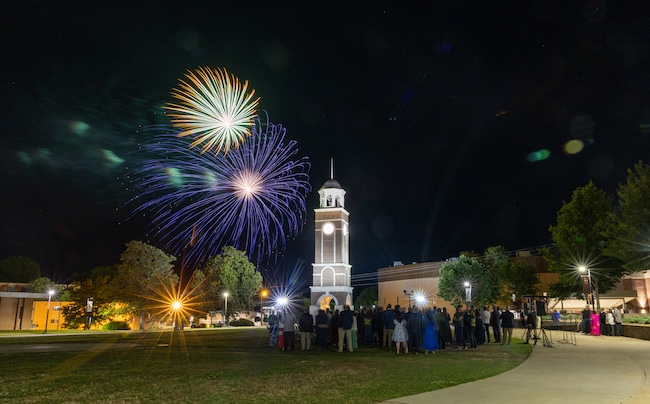 Crowds gather in the FHU commons to watch an evening fireworks show.