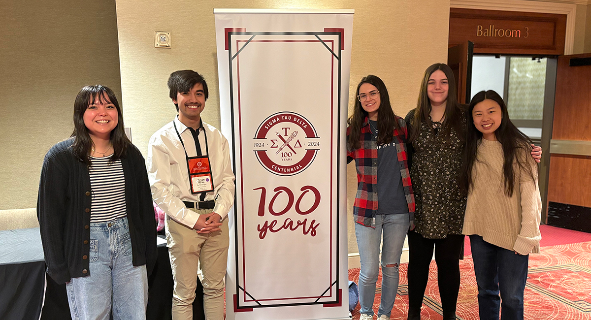 students posing with sign