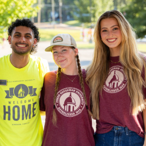 Three FHU students wearing Welcome Home T-shirts smiling.